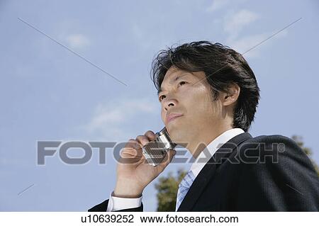 A mid adult businessman talking over a mobile phone View Large Photo Image Stock Image - A mid adult businessman talking over a mobile phone. Fotosearch