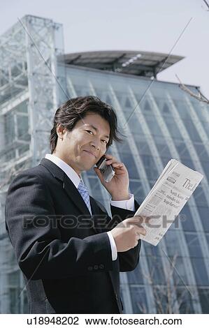 A mid adult businessman talking over a mobile phone View Large Photo Image Stock Image - A mid adult businessman talking over a mobile phone. Fotosearch