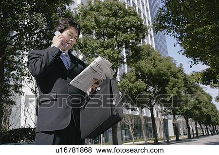 A mid adult businessman talking over mobile phone View Large Photo Image Stock Photo - A mid adult businessman talking over mobile phone. Fotosearch