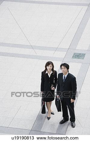 A young businesswoman and mid adult businessman standing View Large Photo Image Stock Image - A young businesswoman and mid adult businessman standing. Fotosearch