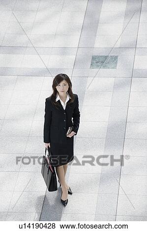 Stock Photo - A young businesswoman standing. Fotosearch