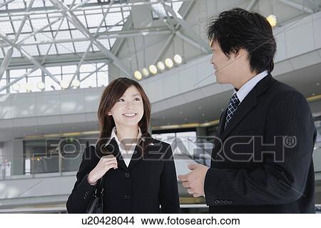 A young woman and a mid adult man talking in lobby View Large Photo Image Picture - A young woman and a mid adult man talking in lobby. Fotosearch