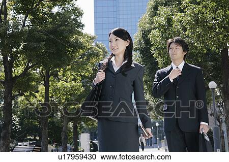 Stock Image - A young woman and mid adult man walking. Fotosearch