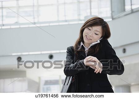 Stock Photograph - A young woman talking over mobile phone. Fotosearch