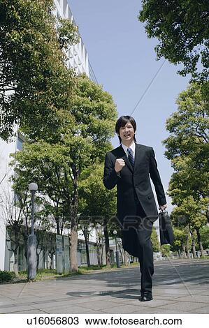 Stock Image - A young man in suit running. Fotosearch