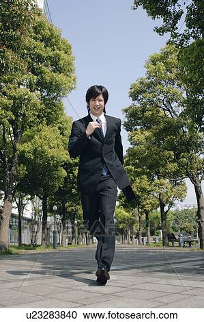 Stock Image - A young man in suit running. Fotosearch