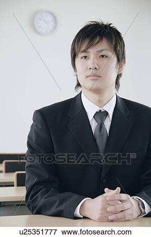 A young man in suit sitting in a meeting room View Large Photo Image Stock Photo - A young man in suit sitting in a meeting room. Fotosearch