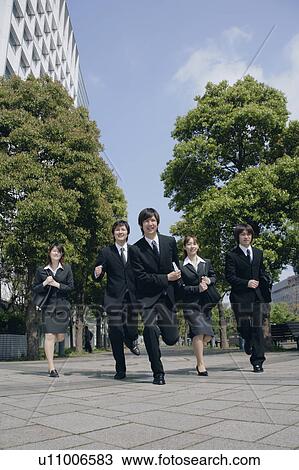 Stock Image - Five young businessperson running. Fotosearch