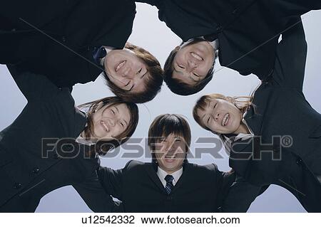 Stock Image - Five young businessperson smiling in circle. Fotosearch