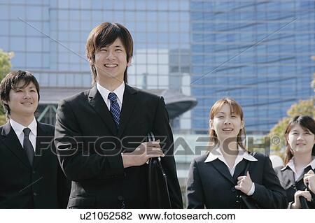Stock Image - Four young businessperson standing. Fotosearch