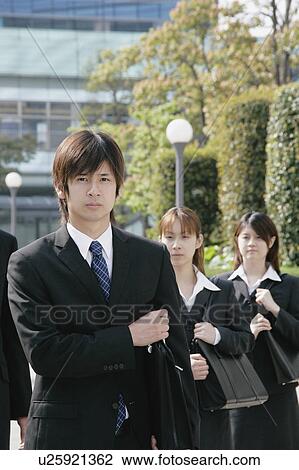 Stock Image - Four young businessperson standing. Fotosearch