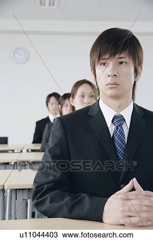 Stock Image - Four young people sitting in a meeting room. Fotosearch