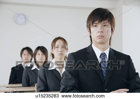 Stock Image - Four young people sitting in a meeting room. Fotosearch
