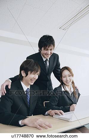 Stock Image - Three young businessperson working. Fotosearch