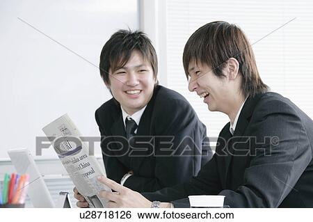 Two young businessperson reading newspaper View Large Photo Image Stock Photograph - Two young businessperson reading newspaper. Fotosearch