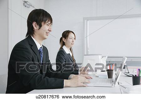 Two young businessperson working in office View Large Photo Image Stock Photograph - Two young businessperson working in office. Fotosearch