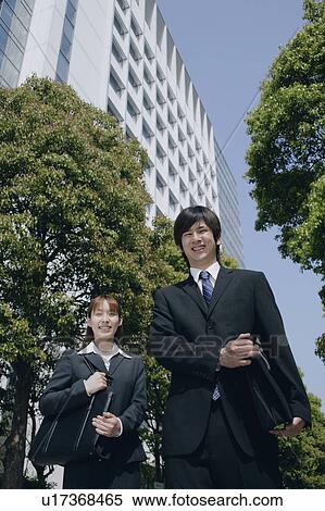 Stock Photography - Young woman and man in suit smiling. Fotosearch