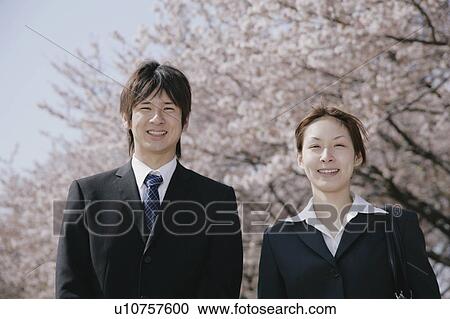 Young woman and man in suit standing View Large Photo Image Stock Image - Young woman and man in suit standing. Fotosearch