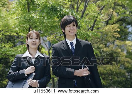 Young woman and man in suit standing View Large Photo Image Stock Image - Young woman and man in suit standing. Fotosearch