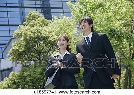 Young woman and man in suit standing View Large Photo Image Stock Image - Young woman and man in suit standing. Fotosearch
