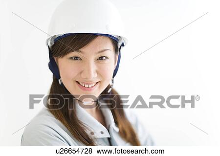 Stock Photo - A female construction worker wearing a hardhat. Fotosearch