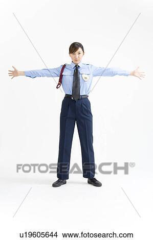 Picture - A female security guard standing with her arms outstretched. Fotosearch