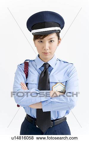 Stock Photo - A female security guard standing with her arms crossed. Fotosearch