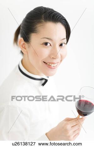 A female sommelier holding a glass of wine View Large Photo Image Stock Photo - A female sommelier holding a glass of wine. Fotosearch