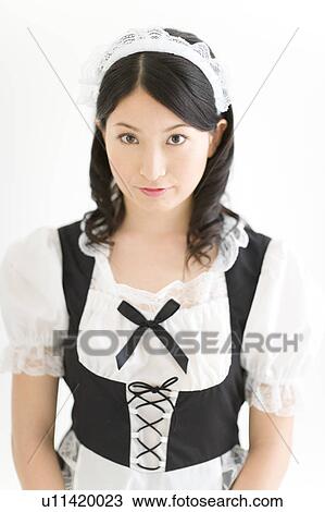 Stock Image - A young woman in French maid outfit smiling. Fotosearch