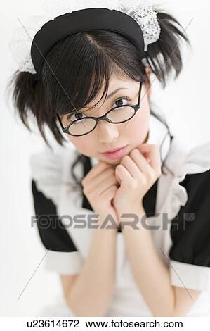 Stock Image - A young woman in French maid outfit smiling. Fotosearch