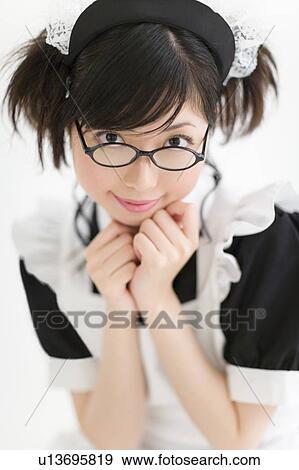 Stock Photo - A young woman in French maid outfit smiling. Fotosearch