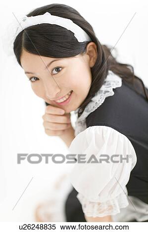 Stock Photography - A young woman in French maid outfit smiling. Fotosearch