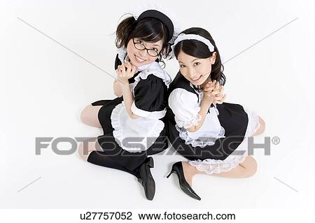 Stock Image - Two young women in French maid outfit smiling. Fotosearch