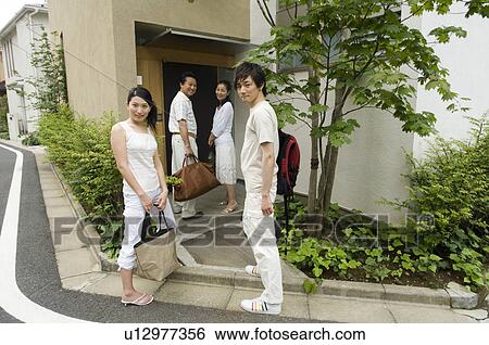 Stock Photograph - A family coming home from a trip. Fotosearch