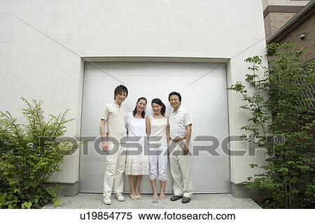 Stock Photography - A family with adult children standing in front of garage. Fotosearch