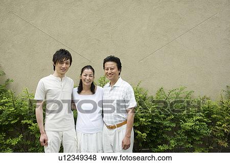 A family with adult son standing in front of house View Large Photo Image Stock Photo - A family with adult son standing in front of house. Fotosearch