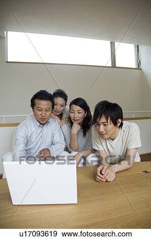 Stock Photo - Family looking at computer. Fotosearch