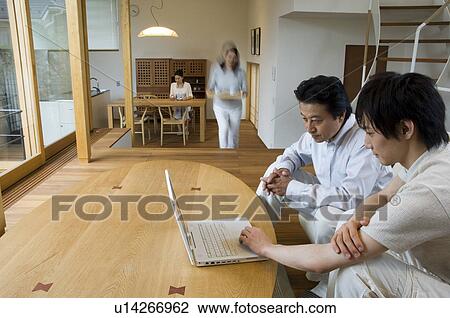 Stock Image - Family relaxing at home, blurred motion. Fotosearch