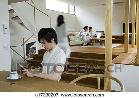 Stock Photo - Family relaxing at home, blurred motion. Fotosearch