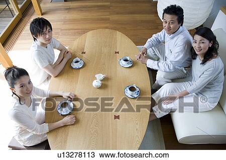 Stock Image - Family relaxing in living room. Fotosearch