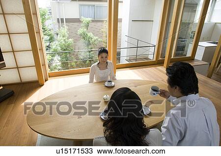 Stock Image - Family relaxing in living room. Fotosearch