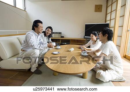Family relaxing in living room View Large Photo Image Stock Image - Family relaxing in living room. Fotosearch