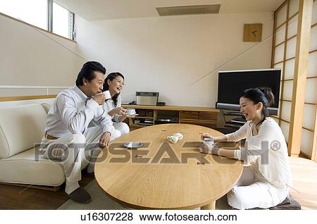 Family relaxing in living room View Large Photo Image Stock Photo - Family relaxing in living room. Fotosearch