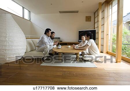 Stock Photo - Family relaxing in living room. Fotosearch