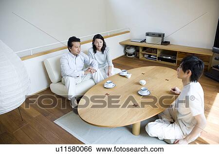 Stock Photograph - Family relaxing in living room. Fotosearch