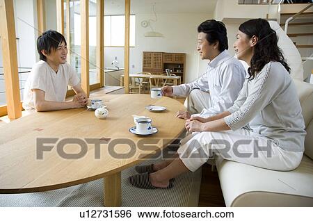 Stock Photograph - Family relaxing in living room. Fotosearch