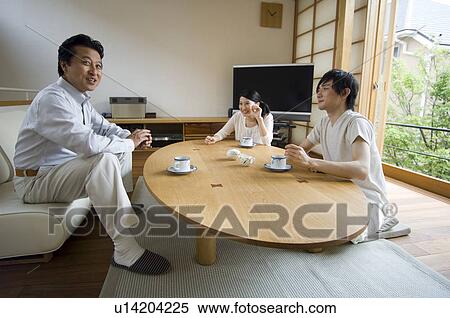 Stock Photography - Family relaxing in living room. Fotosearch