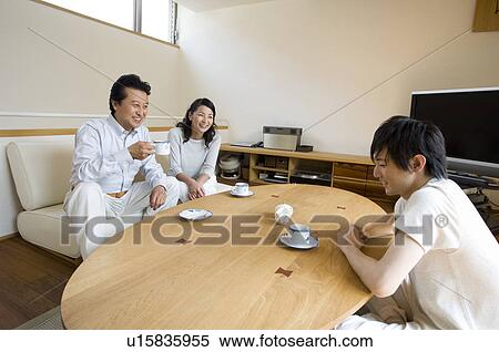 Stock Photography - Family relaxing in living room. Fotosearch