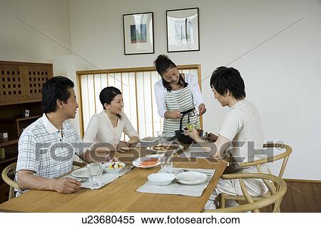 Stock Photography - Family sitting in dining table. Fotosearch