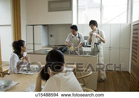 Father and son cooking in kitchen while mother and daughter waiting View Large Photo Image Picture - Father and son cooking in kitchen while mother and daughter waiting. Fotosearch